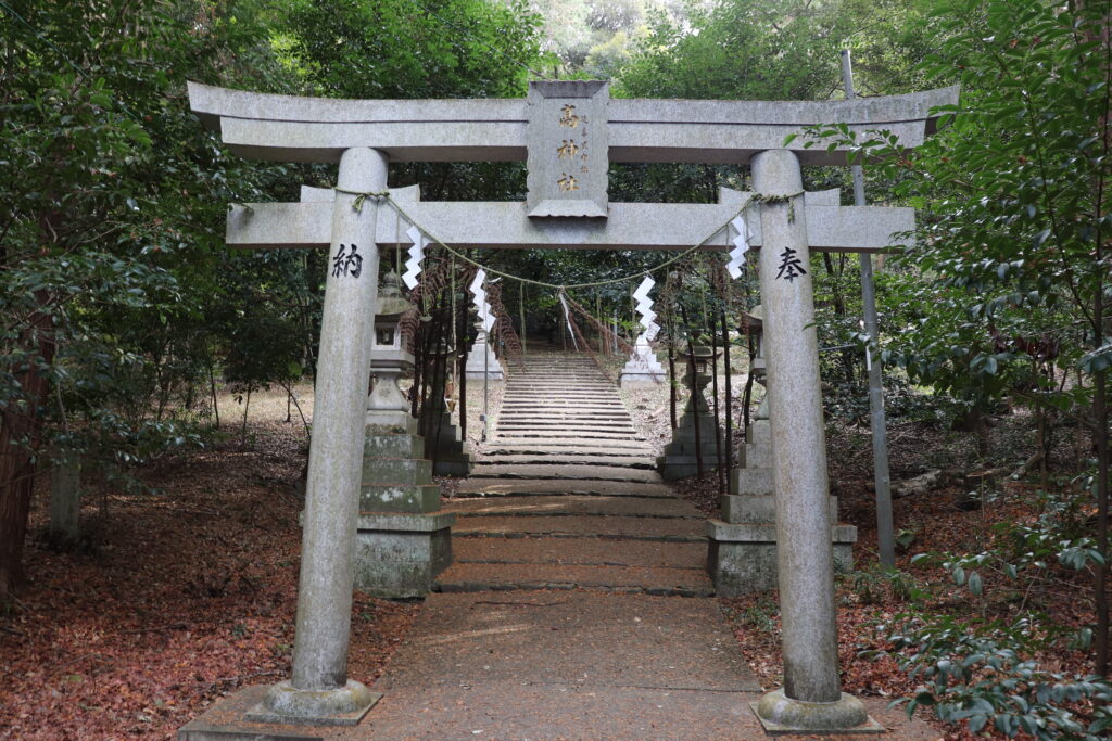 A close-up of a torii gate in the woods