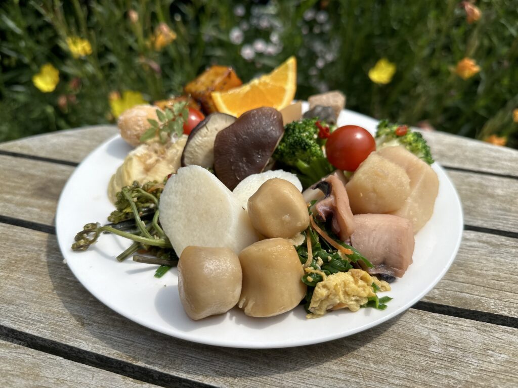 Plate of seasonal vegetables including mushrooms, potatoes, and foraged greens