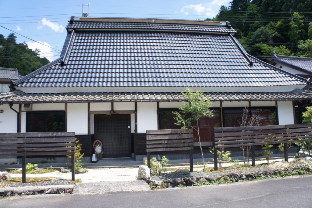 The beautiful exterior of Nio no Yado Baiko, a renovated traditional Japanese kominka guesthouse with a tiled roof.