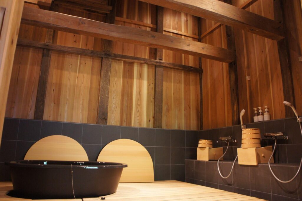 The luxurious Japanese-style bathroom at Nio no Yado Komura, featuring a large tub and beautiful hinoki wood interior.